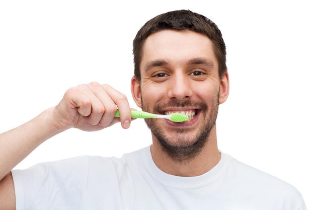 conceito de saúde e beleza - jovem sorridente com escova de dentes