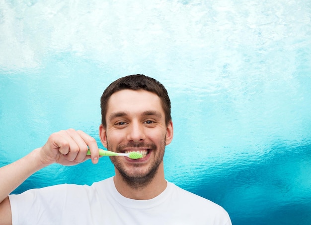 conceito de saúde e beleza - jovem sorridente com escova de dentes