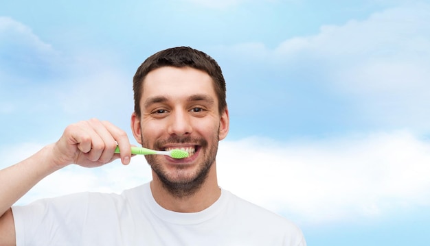 conceito de saúde e beleza - jovem sorridente com escova de dentes