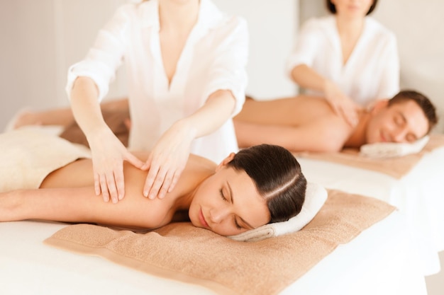 conceito de saúde e beleza, resort e relaxamento - casal em salão de spa recebendo massagem