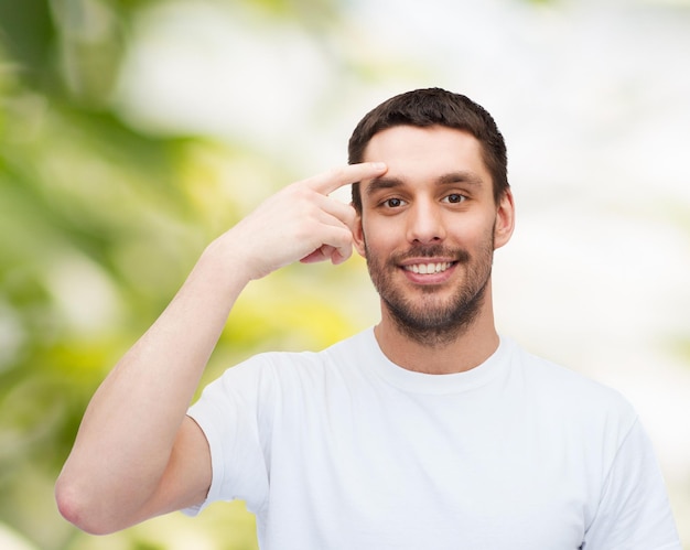 Foto conceito de saúde e beleza - sorridente jovem bonito apontando para a testa