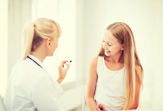 conceito de saúde e medicina - médico com criança medindo temperatura no hospital