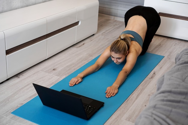 Conceito de saúde. mulher meditando ou fazendo exercícios de ioga em casa. relaxamento. posições do gato de ioga.