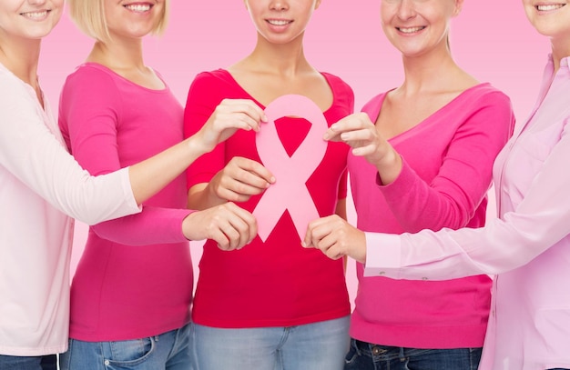 conceito de saúde, pessoas e medicina - close-up de mulheres em camisas em branco com fita de conscientização de câncer de mama sobre fundo rosa