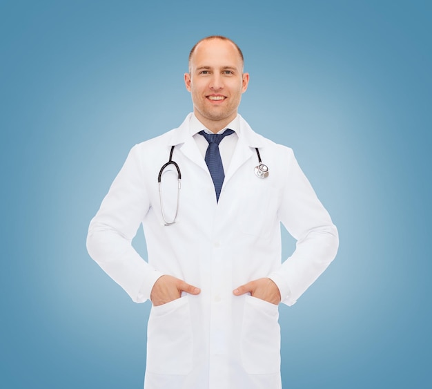 conceito de saúde, profissão e medicina - médico sorridente com estetoscópio em jaleco branco sobre fundo azul