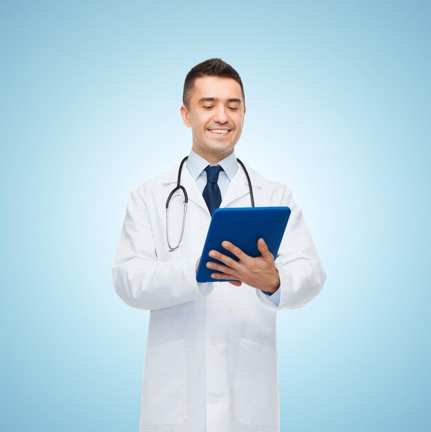 conceito de saúde, profissão, pessoas e medicina - médico sorridente de jaleco branco com tablet pc sobre fundo azul