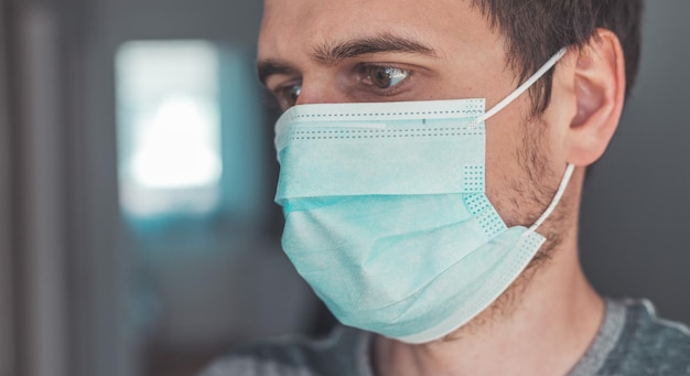 Conceito de segurança contra gripe e corona Retrato de homem usando máscara facial para se proteger