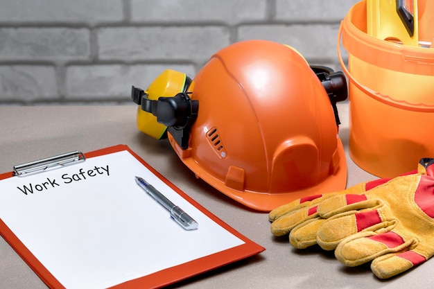 Foto conceito de segurança no trabalho texto de segurança no trabalho na lista e equipamento de proteção de segurança no trabalho no local de trabalho do construtor.