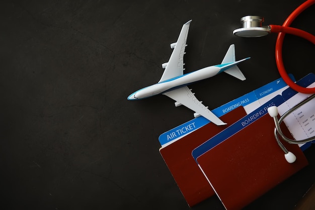 Conceito de seguro aéreo de passageiros Passaporte de avião e estetoscópio