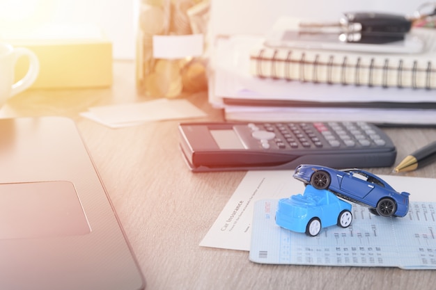 Conceito de seguro de carro: formulário de pedido de carro com acidente de brinquedo de carro na mesa