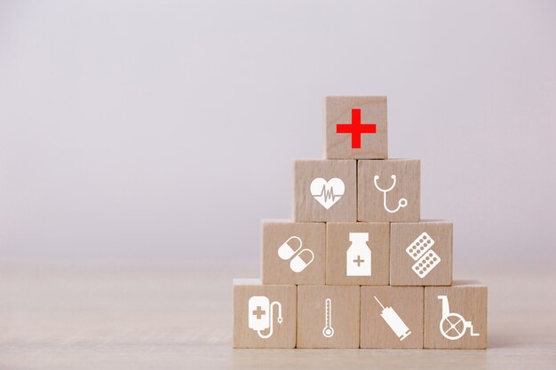 Conceito de seguro de saúde, mão organizando o empilhamento de bloco de madeira com cuidados de saúde de ícone médica, para a saúde