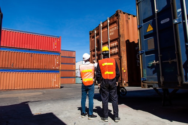 Conceito de seguro marítimo e transportador. Homem de dois portos trabalhando no pátio de contêineres. Controle de contramestre carregando caixa de contêineres no porto de embarque. Conceito de logística de negócios de importação e exportação.