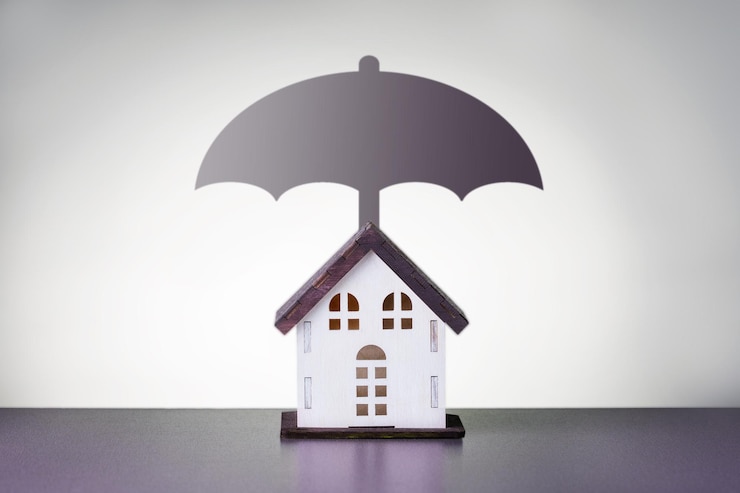 Foto conceito de seguro residencial cottage com guarda-chuva em fundo cinza com espaço de cópia