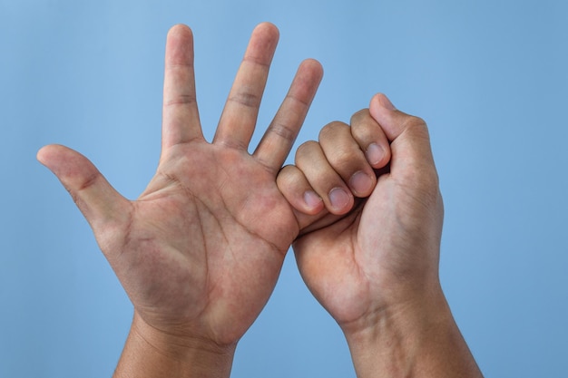 Conceito de síndrome de escritório Little Finger é massageado e esticado após o trabalho Close up shot isolado em fundo azul Vista frontal