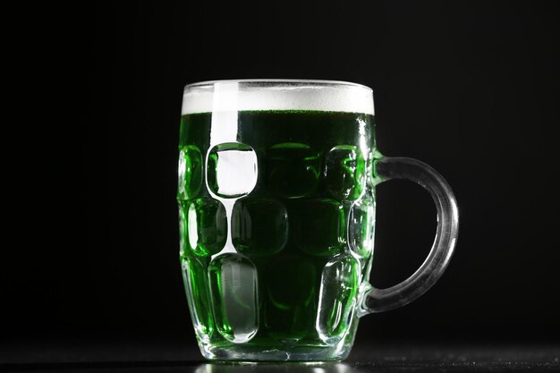 Conceito de St Patrick Day Copo de cerveja verde em fundo preto