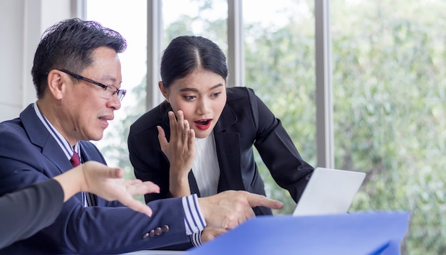 Conceito de sucesso; equipe de negócios Olha para a tela do laptop com expressão de alegria e excitação. Trabalhador de escritório feminino surpreso no local de trabalho.