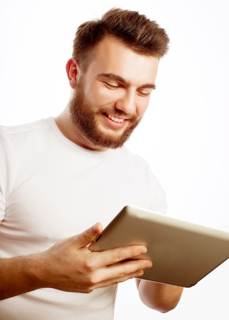 Conceito de tecnologia e estilo de vida: jovem vestindo uma camiseta branca usando um computador tablet - isolado sobre um fundo branco