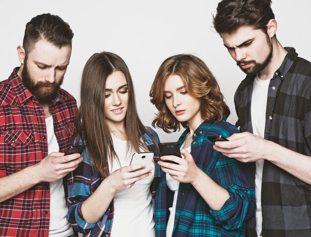 Foto conceito de tecnologia e internetgrupo de jovens a olhar para os seus smartphones