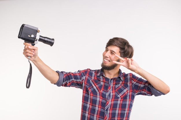 Conceito de tecnologia, fotografia e pessoas - Homem engraçado em camisa xadrez tirando uma selfie sobre fundo branco