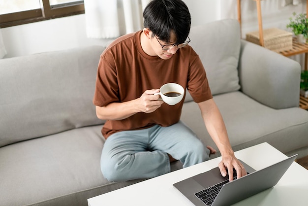 Conceito de tecnologia O homem de camiseta marrom usando uma mão digitando em seu laptop