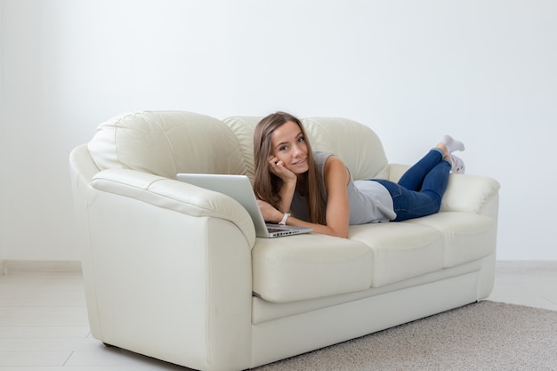 Foto conceito de tecnologias, relaxamento e pessoas - bela jovem deitada no sofá e conversando em casa