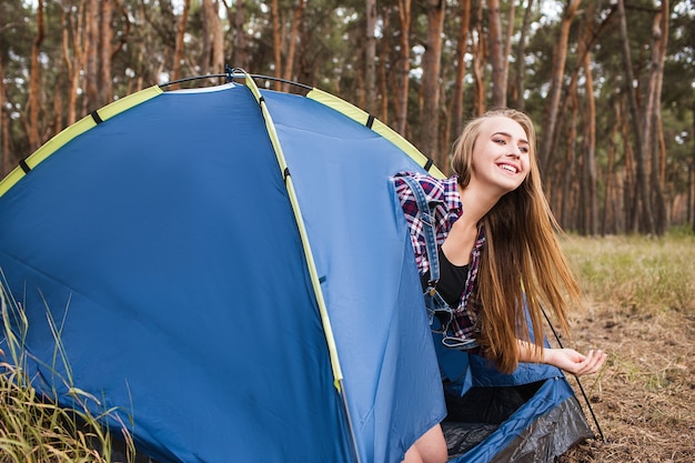 Conceito de tenda de relaxamento de mulher feliz. Anúncio de equipamento turístico. Unidade com a natureza.