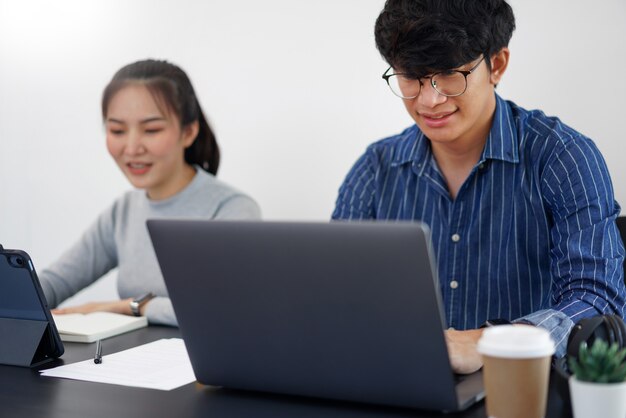 Conceito de trabalho de escritório dois empresário trabalhando nos dispositivos com duas xícaras de café no escritório.