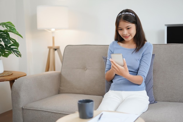 Conceito de trabalho em casa Mulheres de negócios estão lendo dados no smartphone enquanto trabalham remotamente em casa