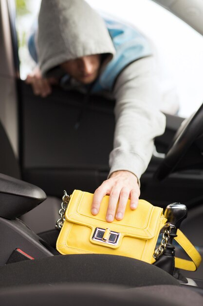 conceito de transporte, crime e propriedade - ladrão roubando bolsa do carro