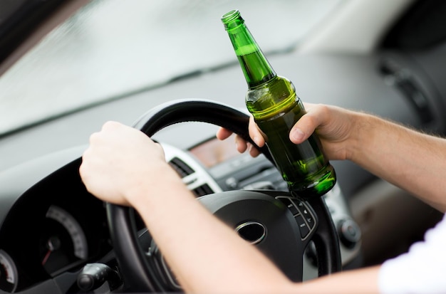 conceito de transporte e veículo - homem bebendo álcool enquanto dirige o carro