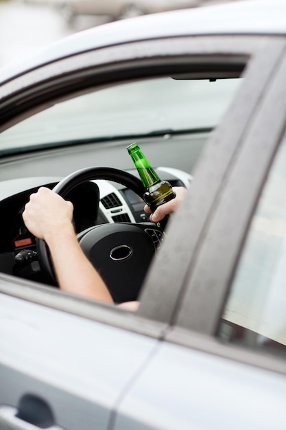 Conceito de transporte e veículo - homem bebendo álcool enquanto dirige o carro