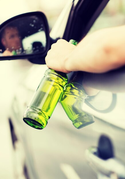 Conceito de transporte e veículo - homem bebendo álcool enquanto dirige o carro