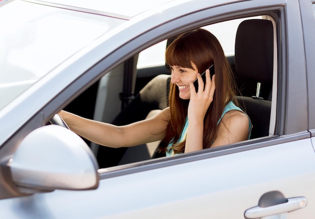conceito de transporte e veículo - mulher usando o telefone enquanto dirige o carro