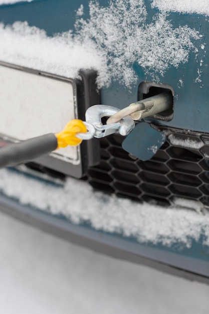 conceito de transporte, inverno e veículo - closeup de carro rebocado com corda de reboque