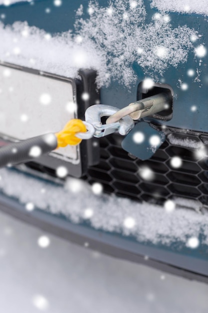 conceito de transporte, inverno e veículo - closeup de carro rebocado com corda de reboque