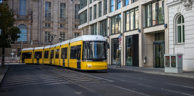 Conceito de transporte público O bonde elétrico amarelo viaja na cidade de Berlim Alemanha Buildings banner de fundo