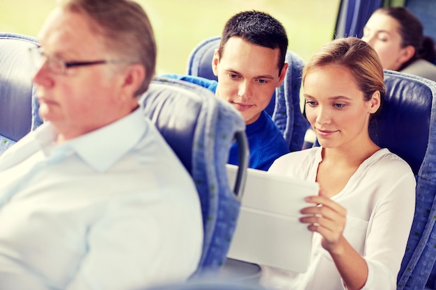 conceito de transporte, turismo, viagem, tecnologia e pessoas - casal feliz com tablet pc em ônibus de viagem