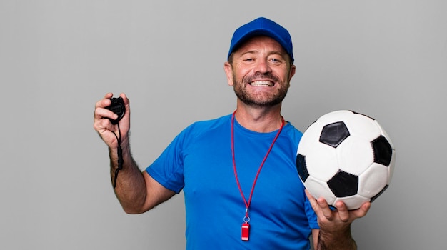 Foto conceito de treinador de esporte de homem de meia-idade com uma bola de futebol
