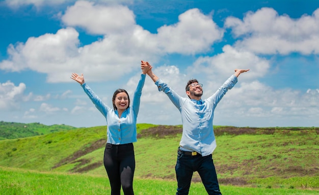 Conceito de um casal feliz e livre no campo Casal na colina com as mãos levantadas para o céu Casal feliz no campo levantando as mãos para o céu