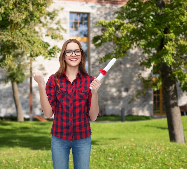 conceito de universidade e educação - aluna sorridente em óculos com diploma