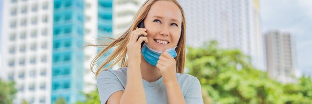 Foto conceito de uso impróprio de máscara mulher usando máscara errada tirou a máscara enquanto falava ao telefone