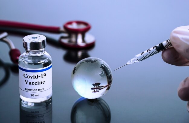Conceito de vacinação globo de vidro com frasco de vacina coronavírus