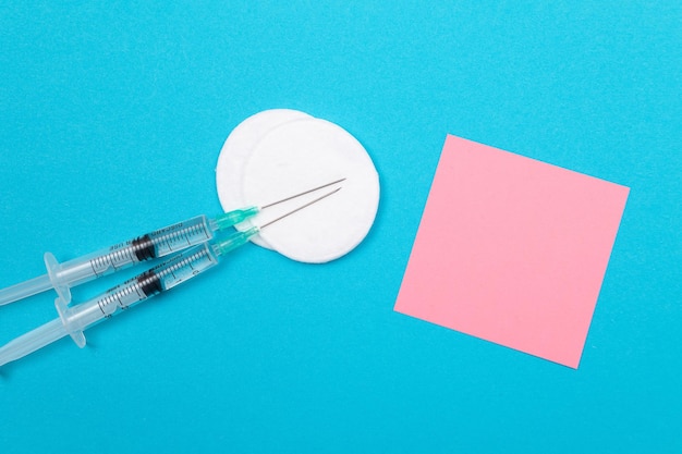 Foto conceito de vacinação ou revacinação duas seringas médicas na mesa azul