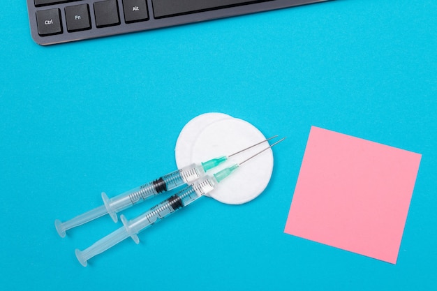 Conceito de vacinação ou revacinação duas seringas médicas na mesa azul