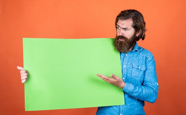 Conceito de venda de economia de outono de homem brutal de propaganda com barba e bigode procura um local de trabalho para espaço de cópia homem barbudo sério com serviço de barbearia de folha de papel vazia