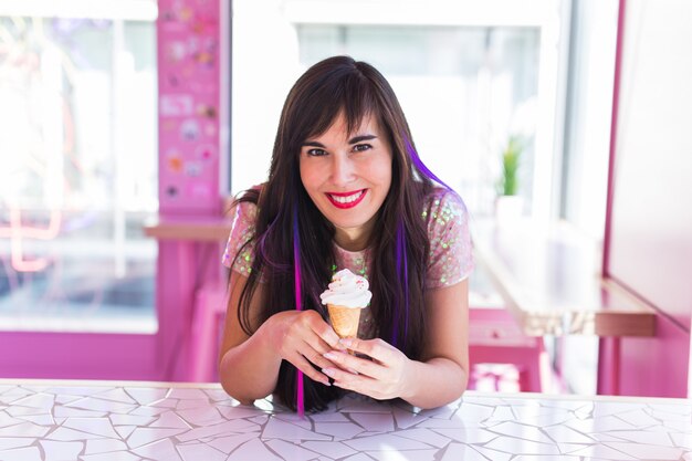 Conceito de verão, juventude e sobremesa - menina bonita, desfrutando de uma casquinha de sorvete no café