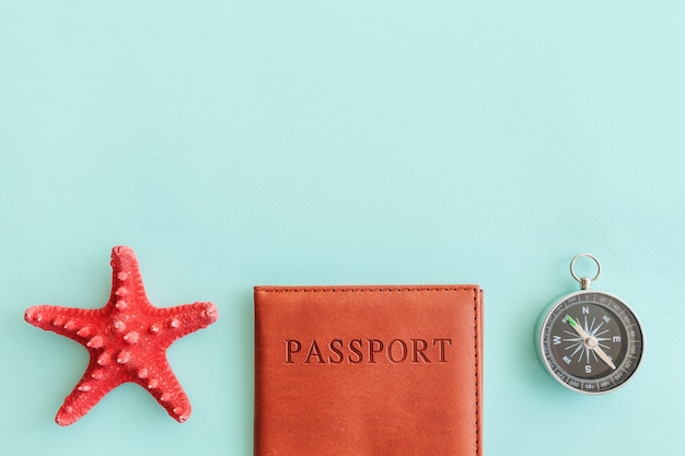 conceito de viagem de aventura de viagens de férias. postura plana com bússola e concha de passaporte em fundo azul