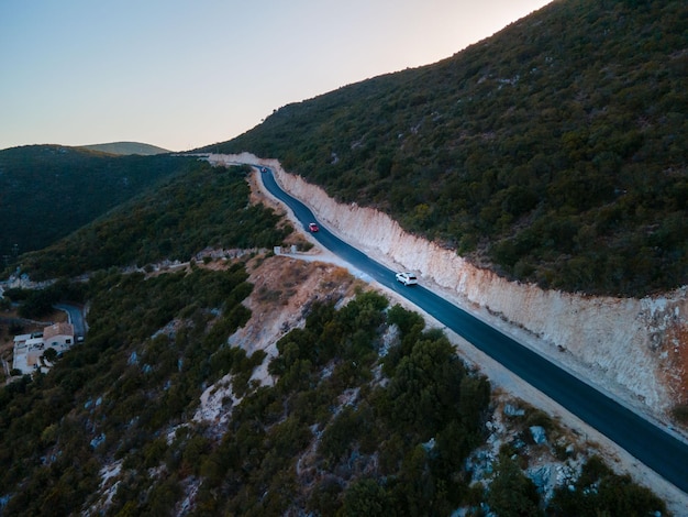 Conceito de viagem de carro movendo-se por estrada nas montanhas com vista para a costa do mar