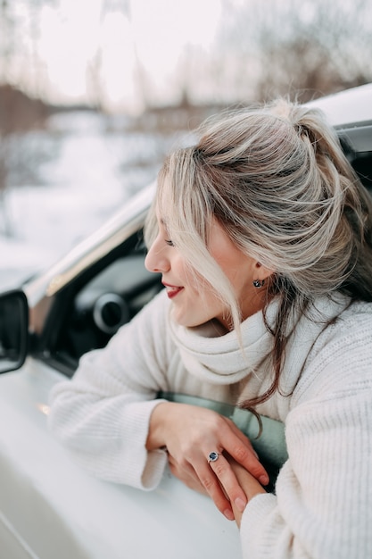 conceito de viagem de inverno, feliz garota viajando olhando pela janela do carro na natureza