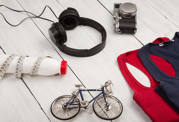 Conceito de viagem e esporte bicicleta modelo camisas fones de ouvido câmera garrafa de água e fita de centímetro